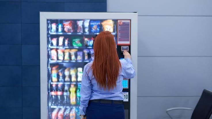 Employee buying a snack from a touchscreen vending machine at work